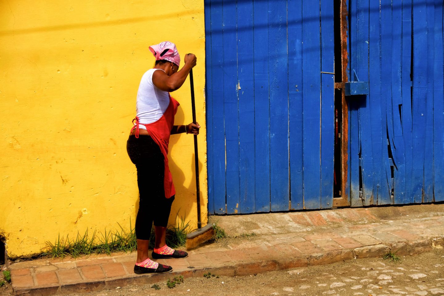 Cuban woman cleans the streets in Trinidad. Daily life in Cuba.