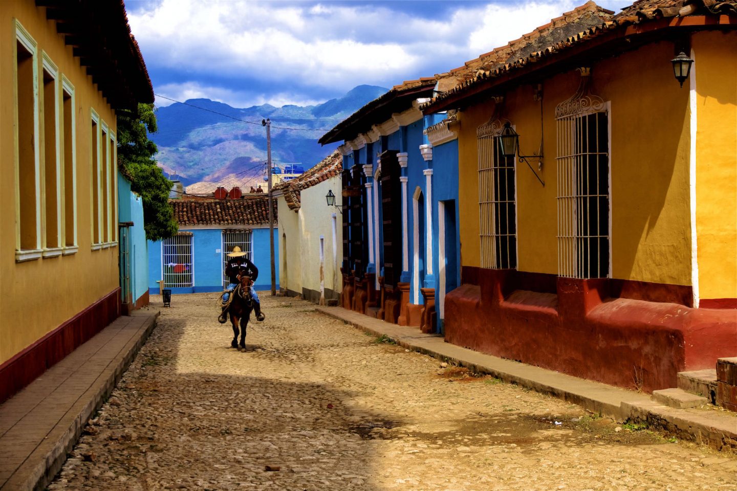 Cowboy riding down a street in Trinidad. Daily life in Cuba.