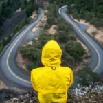 Traveler standing at a literal crossroads, looking thoughtfully at diverging paths, symbolizing adaptability, courage, and open-mindedness